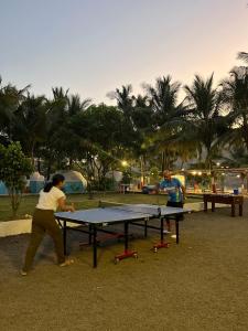 dos personas jugando ping pong en una mesa de ping pong en Off The Grid Glamps en Khopoli