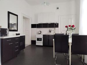 a kitchen with black cabinets and a table with roses at Downtown Delight: Chic Oasis in Zagreb