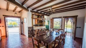 comedor con mesa de madera y sillas en Casa Rosario Almachar by Ruralidays, en Almáchar