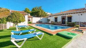 un patio con piscina, 2 sillas y una casa en Casa Rosario Almachar by Ruralidays, en Almáchar