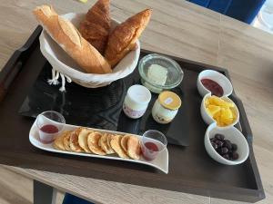 una bandeja con bollería y otros alimentos en una mesa en chambres d'hotes chez Linda Stéphane le passé composé, 