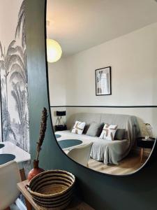 einen Spiegel in einem Zimmer mit einem Bett und einem Sofa in der Unterkunft Le Nid Vert, T2 cocooning à Rennes, proche gare in Rennes
