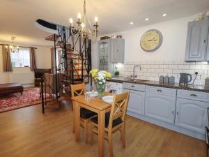 a kitchen with a table and a clock on the wall at The Old Sorting Office in Hawarden