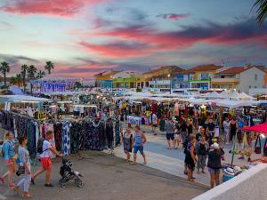 a crowd of people walking around a market with tents at Le Charly in Le Barcarès