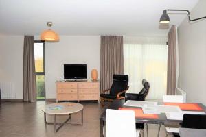 ein Wohnzimmer mit einem Tisch, Stühlen und einem TV in der Unterkunft Maison neuve de plain-pied avec WIFI classée 3 étoiles à Trégastel Ref 466 in Trégastel