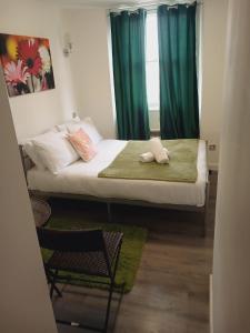 a small bedroom with a bed with green curtains at Stunning Studio For 2 Near Hyde-f303 in London