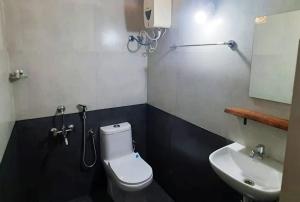 La salle de bains est pourvue de toilettes blanches et d'un lavabo. dans l'établissement BLUE SOPHY Residency, à Varkala