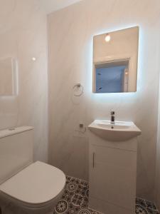 a white bathroom with a toilet and a sink at Centra Station in London