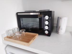 a black microwave sitting on a counter with glasses at Centra Station in London