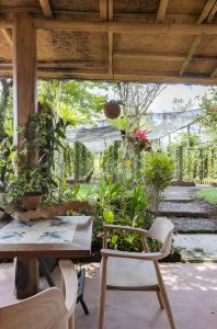 un patio con mesa, sillas y plantas en Hidden paradise en Angsri