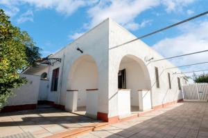a white building with arches on the side at Villetta Oasis in Punta Prosciutto