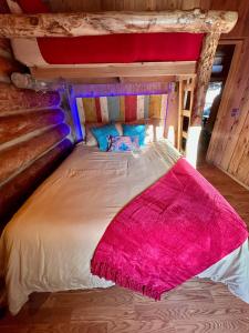 a bed with a pink blanket on top of it at Boulder Mountain Guest Ranch in Boulder Town