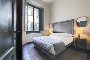 a bedroom with a large bed and two windows at Apartments Florence- Palazzo Benci with river view · Palazzo Benci with river view in Florence