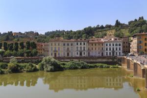 a bridge over a river with buildings in the background at Apartments Florence- Palazzo Benci with river view · Palazzo Benci with river view in Florence