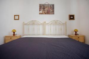 a bedroom with a large bed and two night stands at Villetta Oasis in Punta Prosciutto