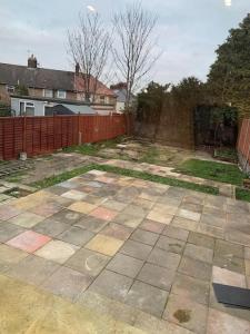 a yard with a fence and a stone patio at Beautiful 5Bedroom Hse-Contractor/Family/Corporate in Kent