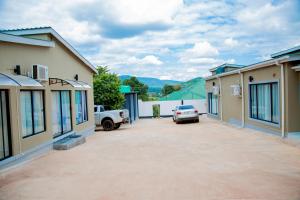 a parking lot in the middle of two buildings at Modern Village Apartments in Chipata