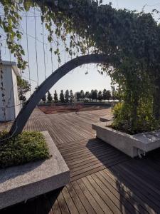 a metal arch over a wooden deck with plants at Sutera Avenue - Jom Summer Suite in Kota Kinabalu