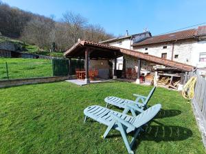 Deux bancs blancs assis dans la cour d'une maison dans l'établissement Vivienda turística La Magdalena, à Vallejuelo