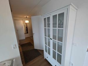 um quarto com um armário branco com portas de vidro em Central apartment with a view em Växjö
