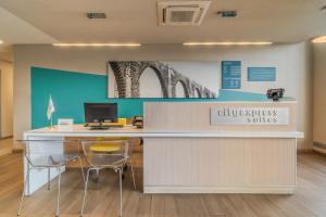 an office with a desk with a computer and chairs at City Express Suites by Marriott Queretaro in Querétaro