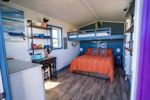 a bedroom with a bed in a tiny house at Ravens Rest Retreat 