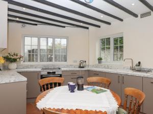 a kitchen with a table and chairs in a room at Glebe Cottage in Yelverton
