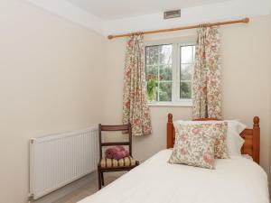 a bedroom with a bed and a window at Glebe Cottage in Yelverton