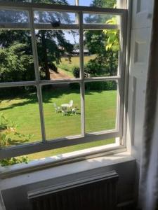 a window with a view of a green yard at Church house in Claines