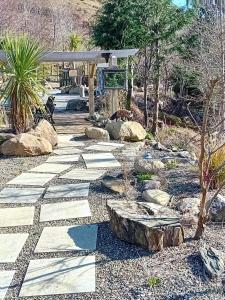 un vialetto in pietra in un giardino con rocce e alberi di Clarisses Cottage a Laragh