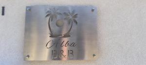 a sign on the side of a building with palm trees at Alba b&b in Polignano a Mare