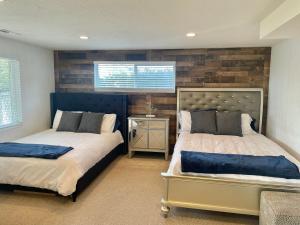 a bedroom with two beds and a wooden wall at City light views getaway close to top ski resorts in Salt Lake City