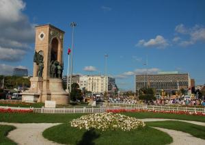 a clock tower with a statue in a park at Green Star Pera Hotel in Istanbul