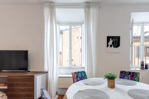 uma sala de estar com uma mesa, uma televisão e uma janela em Casa Pantanella a Palazzo Vecchio em Florença