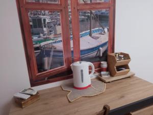 eine Kaffeetasse auf einem Tisch neben einem Fenster in der Unterkunft DOMAINE DE LA LUCARLIERE in Saint-Cyr-des-Gâts