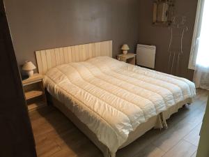 ein Bett in einem Schlafzimmer mit zwei Lampen an Tischen in der Unterkunft Maison avec jardin, à 600m de la mer à TREGASTEL Réf - 57 in Trégastel