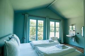 1 dormitorio azul con 2 camas y ventana en In het huis van Bello, en Deventer