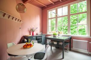 a kitchen with pink walls and a table and a sink at In het huis van Bello in Deventer