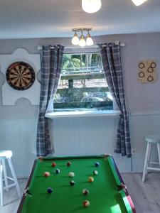 Una habitación con una mesa de billar con pelotas. en Clarisses Cottage, en Laragh