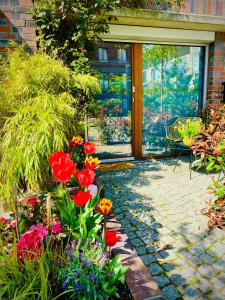 a garden with colorful flowers and a glass door at Schöne Aussichten mitten in Berlin - il sole in Berlin