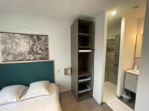 um quarto com uma cama e uma cabina de duche ao nível do chão em APPARTEMENT HYPER CENTRE numéro 101 em Roanne