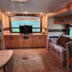 an rv living room with a couch and a flat screen tv at Daisy Lake RV Campground in Nevis