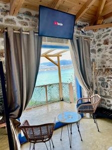 a room with a table and chairs and a view of the ocean at Rocksecret Edge in Kalamata