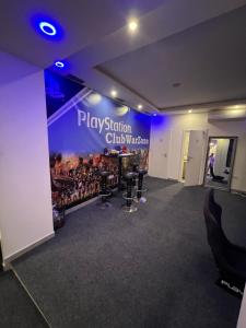 a room with a stage with a sign that reads playidon chicharracies at Club PlayStation “WarZone” Banjaluka in Banja Luka