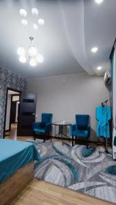 Pokój z 2 niebieskimi krzesłami i stołem w obiekcie Отель Чынгыз 2 w mieście Osz