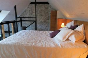 1 dormitorio con 1 cama con sábanas y almohadas blancas en Maisonnette de charme à 400m de la plage à TREGASTEL - Réf 64, en Trégastel