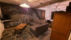a living room with a couch and a table at Les gîtes de la Brasserie d'Aubrives La Malterie et la Houblonnière in Aubrives