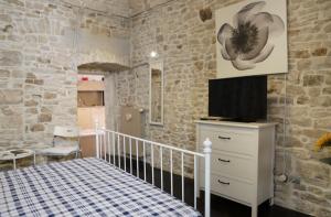 a bedroom with a bed and a tv on a dresser at La Petite Maison in Ruvo di Puglia