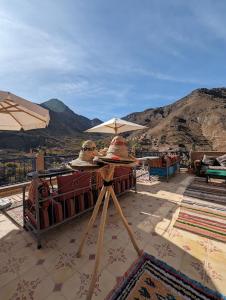 a person sitting under an umbrella on a table at Riad Dar Omar in Imlil