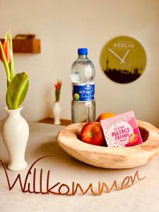a table with a bowl of apples and a bottle of water at Schöne Aussichten mitten in Berlin - il sole in Berlin